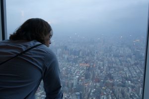 William Bork '11 looking out window over Taipei, Taiwan.