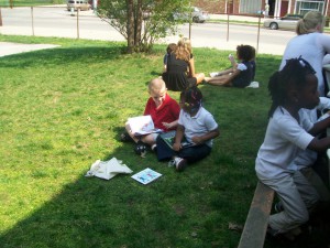 Michael and Jenesis enjoy partner reading outside. 