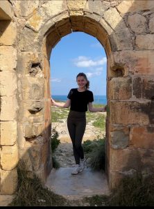 Elizabeth posing in stone archway of Archeological structure in Mellieha