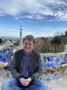 Cody smiling while in Park Guell with the city of Barcelona behind him