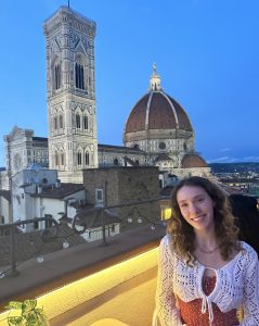 Astrid posing on a balcony in front of the Duomo Florence.