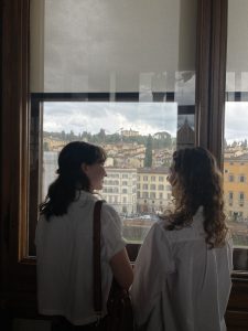 Astrid and a friend looking out a high window at the city of Florence