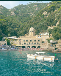 A wooden boat on the water in front of San Fruttuoso
