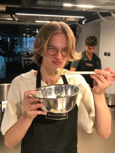 Jonathan trying a taste of the dish he made during a cooking class in Milan