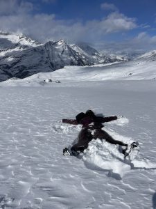 Jordan making a snow angel while hiking the Matterhorn in Zermatt