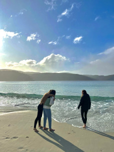 Jessica and two friends walking on the beach in Fortescue Bay, Tasmania