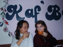 Gabi and friend posing in front of a cafe wall. 