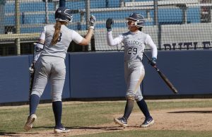 Bri Avery high fives Loren Simpson after scoring a run versus UIC.